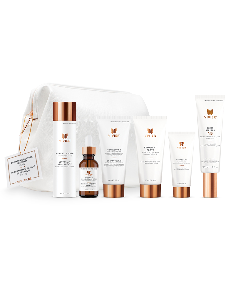 7 Vivier Skincare Programs That Target Dryness, Dark Spots, Aging & More A line of gold and white skincare products positioned in front of a white leather bag on a white backdrop.