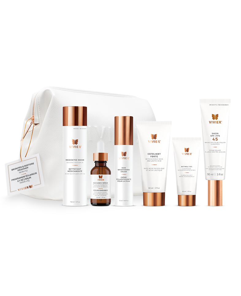 7 Vivier Skincare Programs That Target Dryness, Dark Spots, Aging & More A line of gold and white skincare products positioned in front of a white leather bag on a white backdrop.