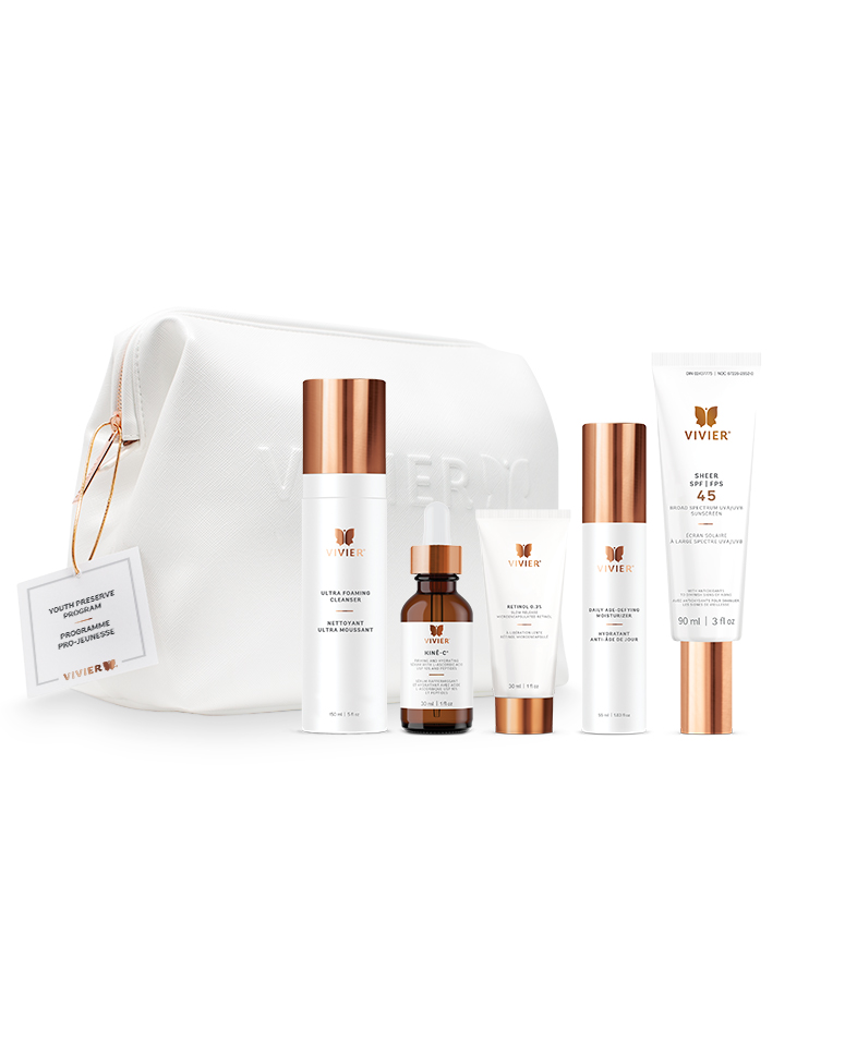 7 Vivier Skincare Programs That Target Dryness, Dark Spots, Aging & More A line of gold and white skincare products positioned in front of a white leather bag on a white backdrop.